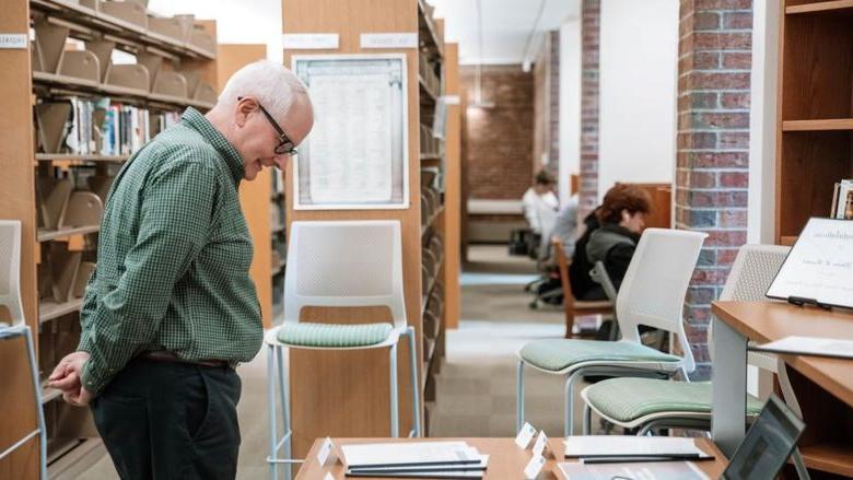 Professor looks at papers on table