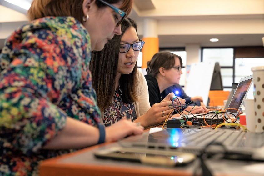 Two women work with Hummingbird Duo robotics kit